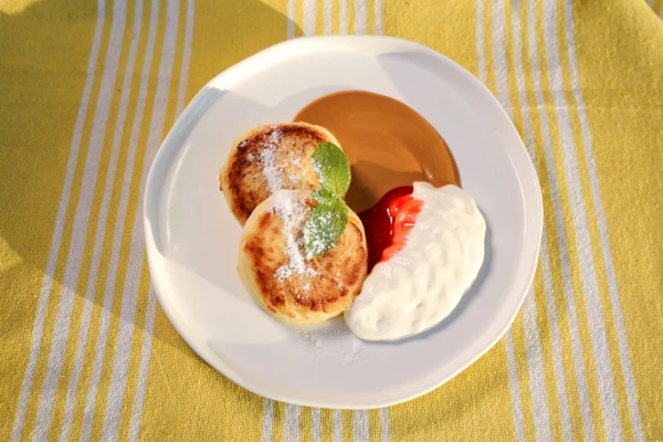 Сырники с малиновым куле, сметаной и варёной сгущенкой