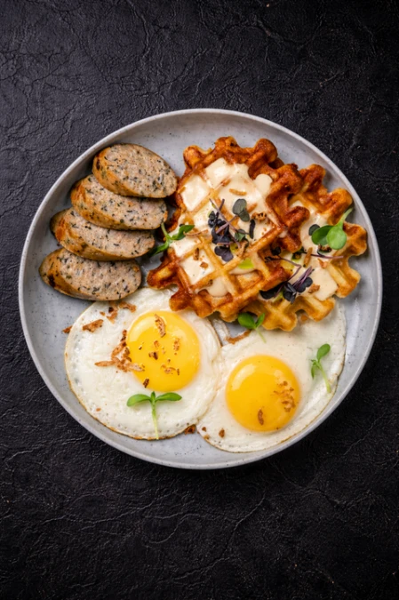 Вафли с куриными колбасками, яйцами и перечным соусом