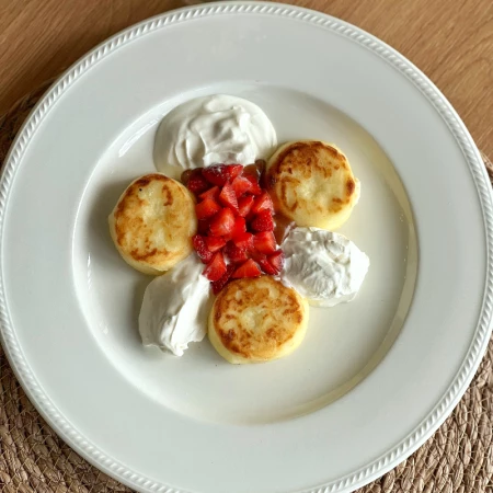 Сырники с клубничным соусом, сметаной и соленой карамелью