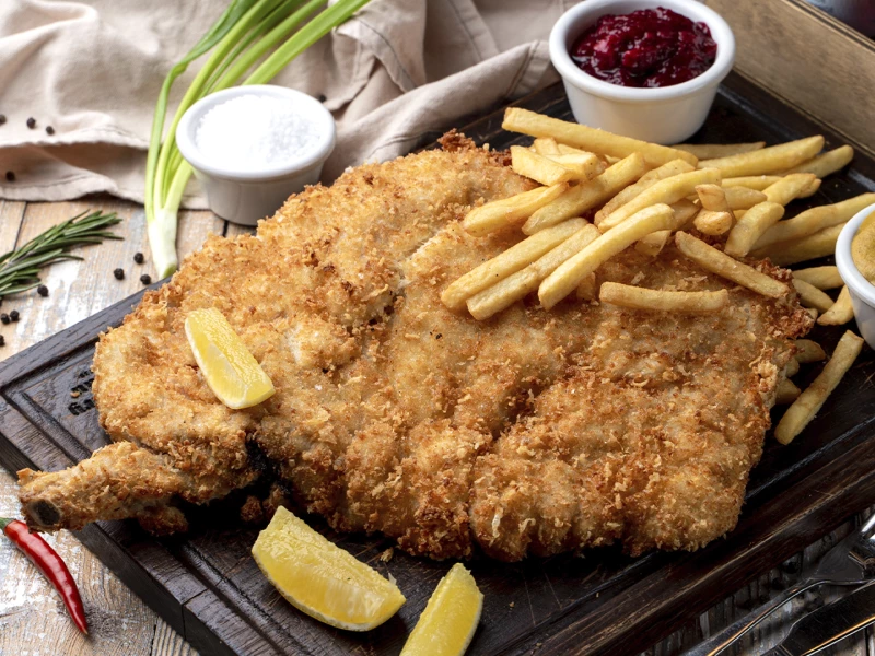 Шницель из свиной шейки с картофелем фри, моченой брусникой и горчицей