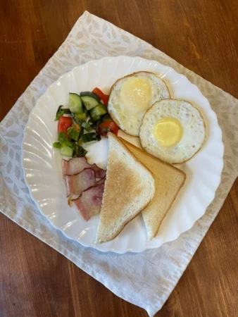 Глазунья с беконом свежими овощами и тостом