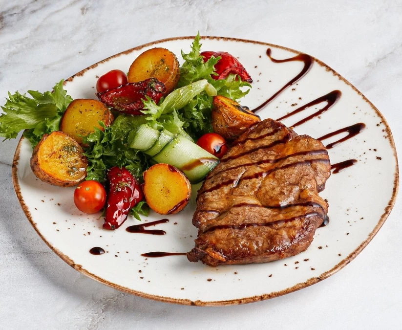 Стейк из свиной шеи со свежими овощами и картофелем беби 