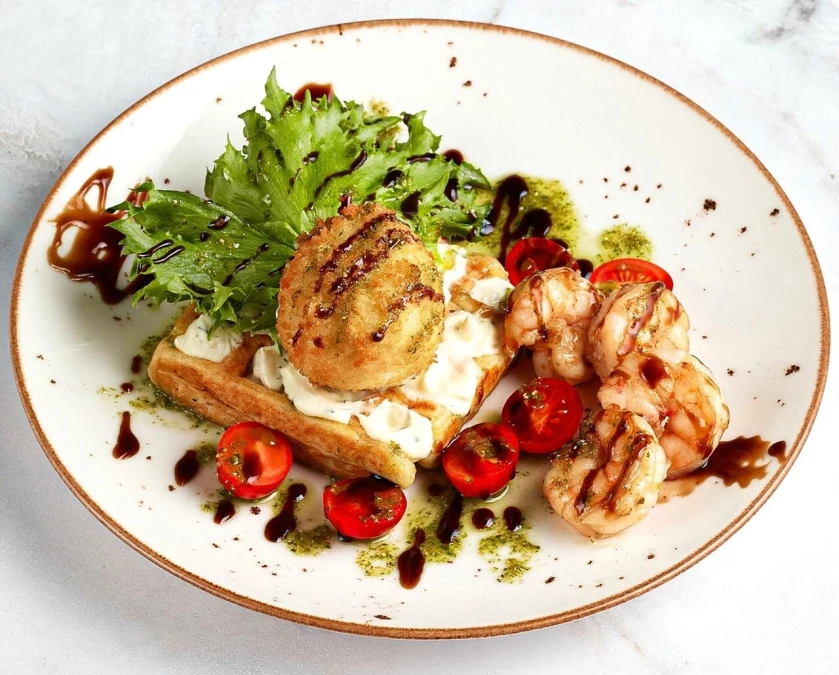 Теплый салат с картофельной вафлей, креветками и панированным яйцом пашот