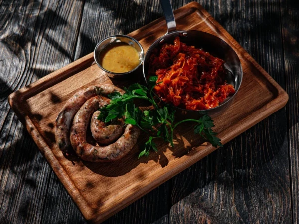 Баранья колбаска с кинзой, чили, тушеной капустой и горчичным соусом