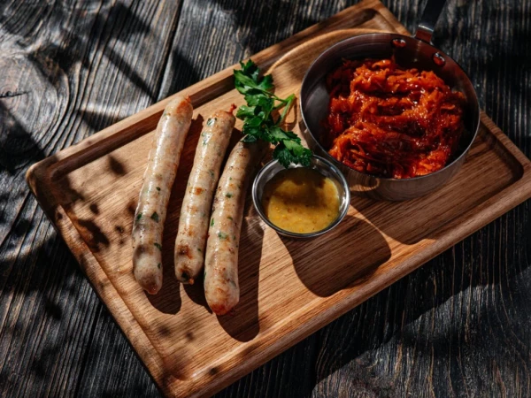 Куриные колбаски с тушеной капустой и горчичным соусом