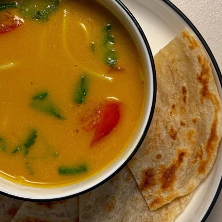 Суп карри с яичной лапшой и лепешкой ротти.